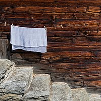 Symbolbild: Ein Handtuch hängt auf einer Leine vor einer Hauswand
